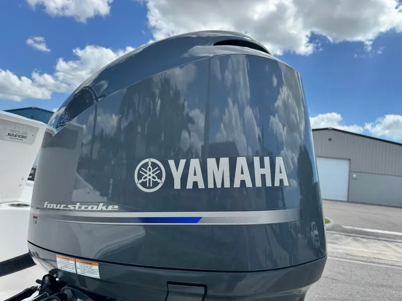 Slide: The Image of Yamaha four-stroke outboard motor on 2016 Wellcraft 241 boat, under a partly cloudy sky. - 13