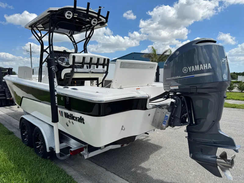 Slide: The Image of 2016 Wellcraft 241 boat with Yamaha engine on trailer, parked outdoors under blue sky. - 15