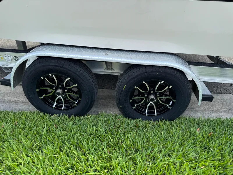Slide: The Image of Trailer wheels of a 2016 Wellcraft 241 boat on grass. - 17
