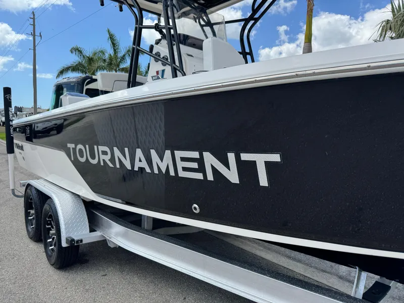 Slide: The Image of 2016 Wellcraft 241 Tournament boat on trailer, side view with palm trees in background. - 22