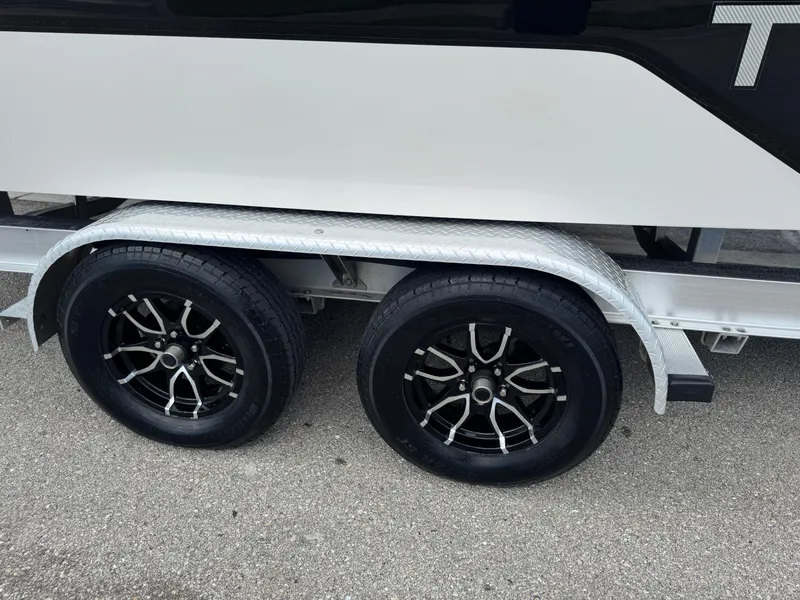 Slide: The Image of Trailer wheels of a 2016 Wellcraft 241 boat on pavement. - 24