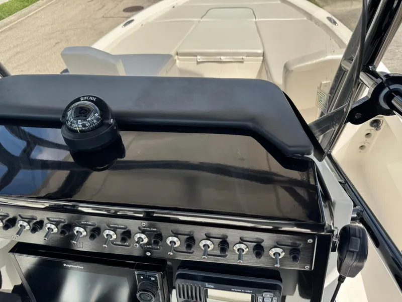 Slide: The Image of Control panel of 2016 Wellcraft 241 boat with compass and switches. - 28