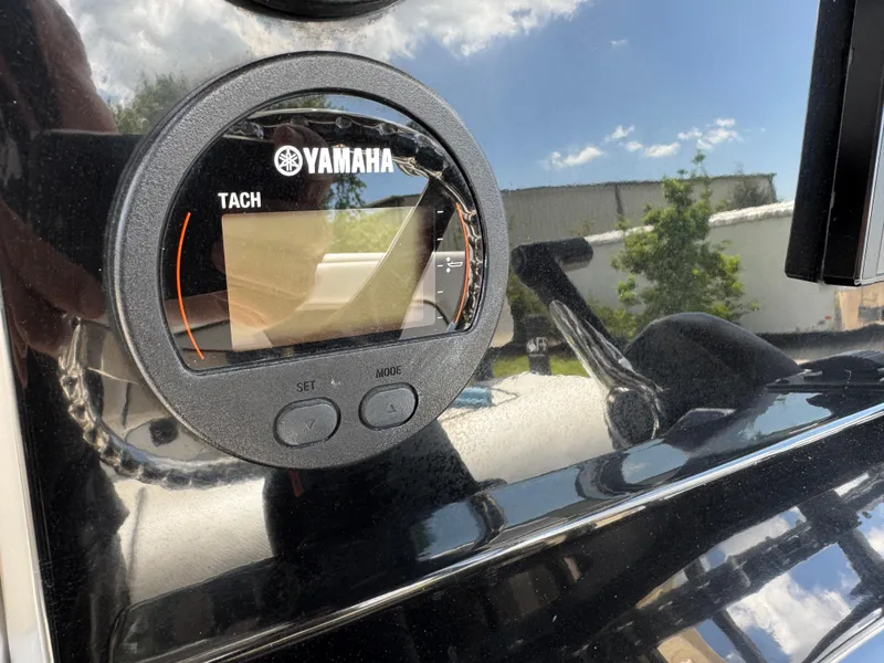 Slide: The Image of Yamaha tachometer on 2016 Wellcraft 241 boat dashboard, reflecting sky and surroundings. - 30