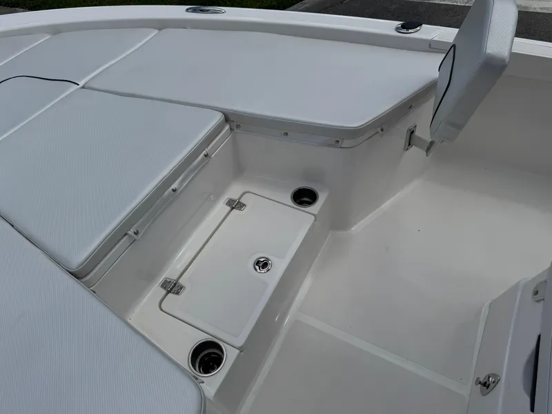 Slide: The Image of 2016 Wellcraft 241 boat interior with white seating and storage compartments. - 39