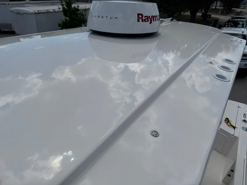 Slide: The Image of 2016 Wellcraft 241 boat roof with Raymarine radar, reflecting cloudy sky. - 47