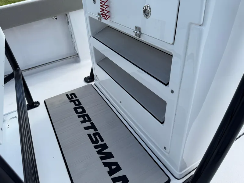 Slide: The Image of 2023 Sportsman Open 212 Center Console interior with storage compartments and branded mat. - 26