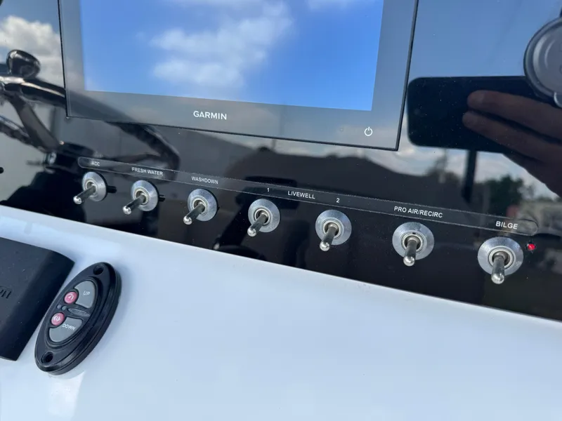 Slide: The Image of 2023 Sportsman Open 212 Center Console dashboard with Garmin display and control switches. - 38