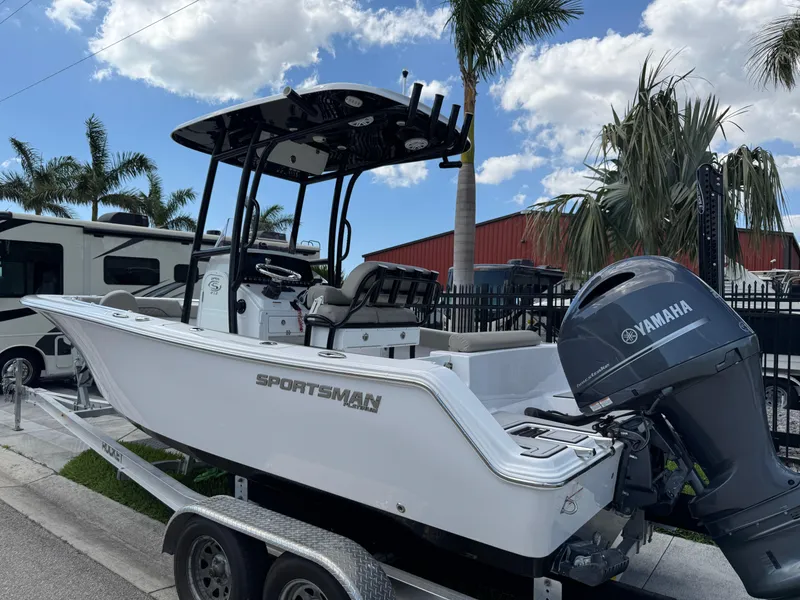 Slide: The Image of 2023 Sportsman Open 212 Center Console boat on trailer, with Yamaha engine, palm trees in background. - 8