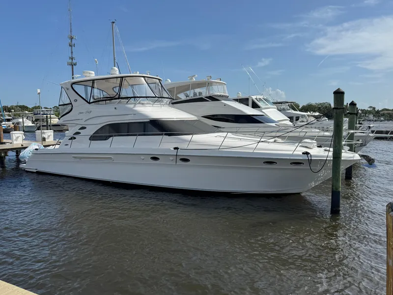 Slide: The Image of 2004 Sea Ray 560 Sedan Bridge yacht docked at marina under clear blue sky. - 0