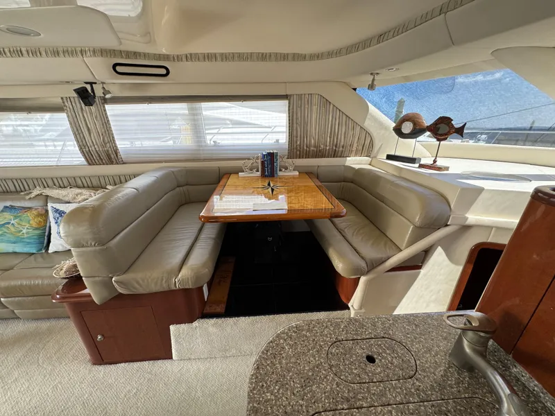 Slide: The Image of Luxurious interior of a 2004 Sea Ray 560 Sedan Bridge yacht with leather seating and dining area. - 14