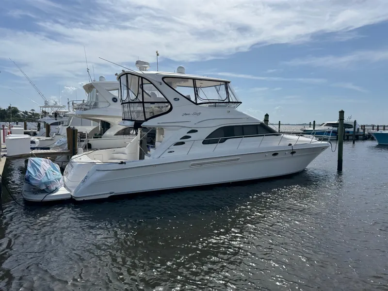 Slide: The Image of 2004 Sea Ray 560 Sedan Bridge yacht docked at marina under clear sky. - 2