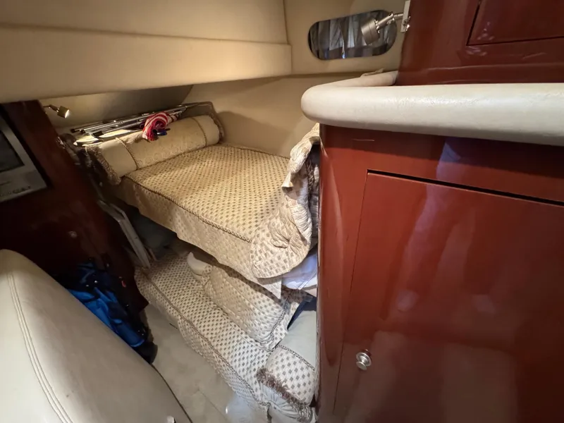 Slide: The Image of 2004 Sea Ray 560 Sedan Bridge interior with bunk beds and wooden cabinetry. - 23
