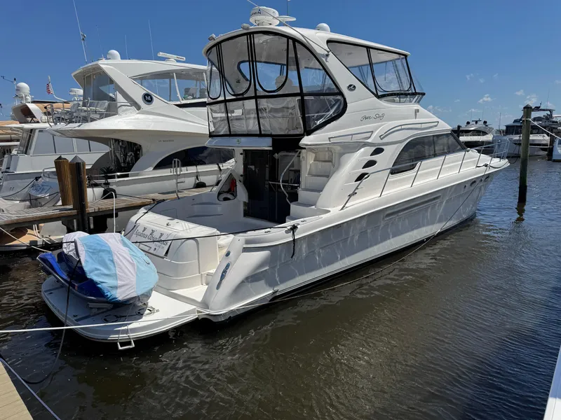 Slide: The Image of 2004 Sea Ray 560 Sedan Bridge yacht docked at marina under clear blue sky. - 3