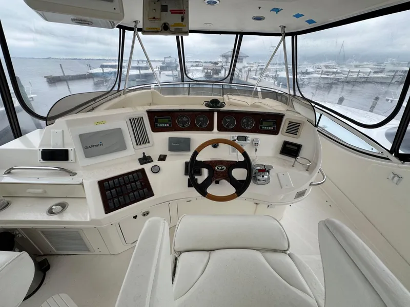 Slide: The Image of 2004 Sea Ray 560 Sedan Bridge helm with steering wheel, controls, and navigation equipment. - 30