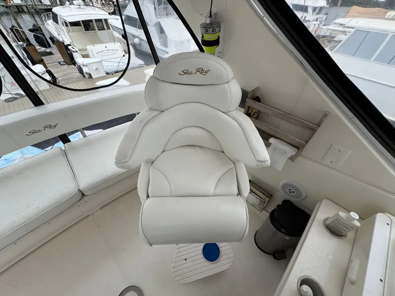 Slide: The Image of Captain's chair on 2004 Sea Ray 560 Sedan Bridge yacht, featuring white upholstery and helm view. - 32