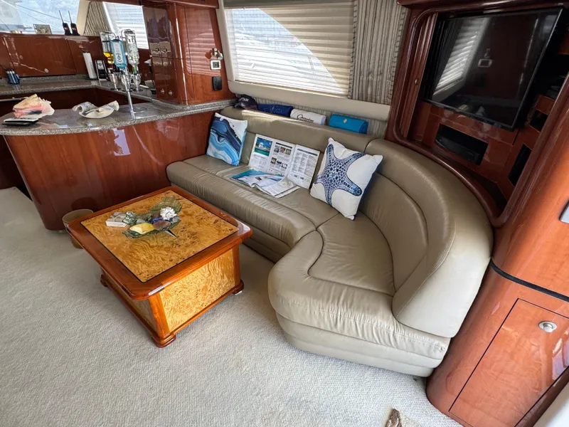 Slide: The Image of Luxurious interior of 2004 Sea Ray 560 Sedan Bridge with leather sofa and elegant wood finishes. - 8