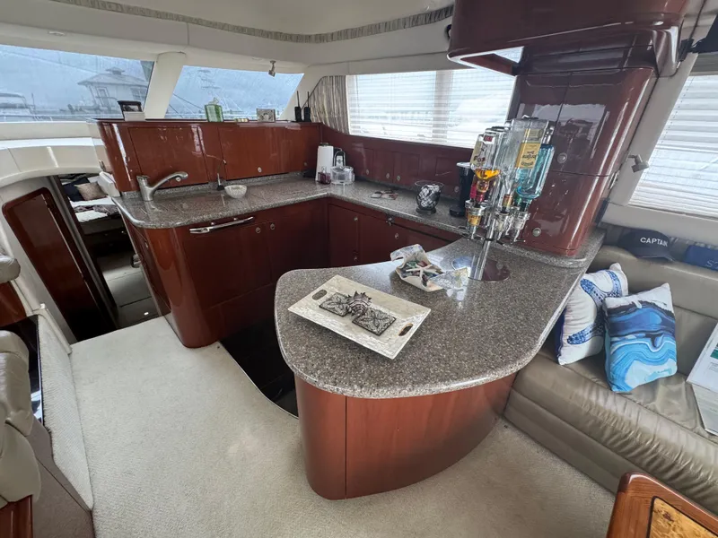 Slide: The Image of Luxurious 2004 Sea Ray 560 Sedan Bridge yacht interior with modern kitchen and seating area. - 9