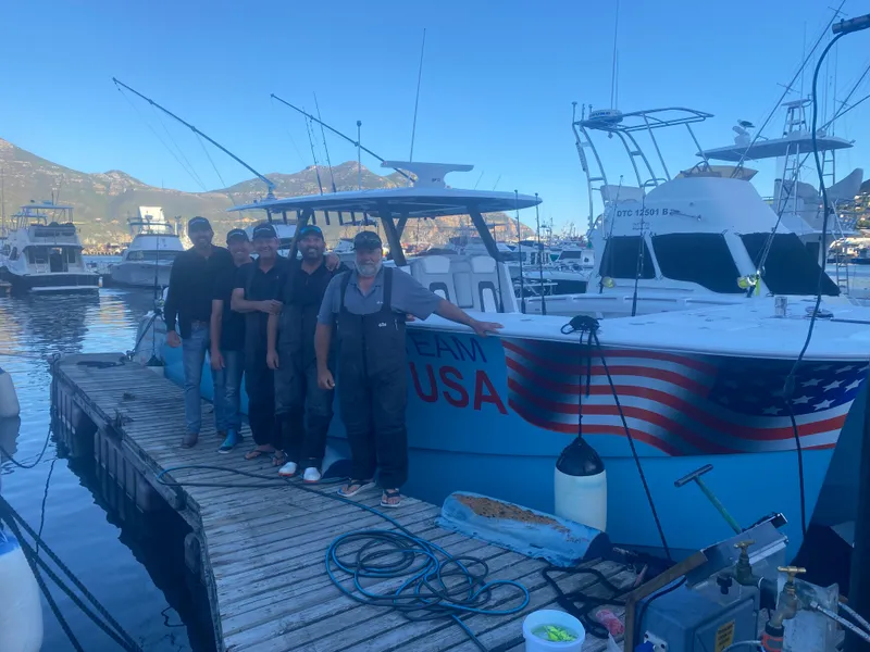 Slide: The Image of Group beside 2025 Hammer Yachts HammerCat 35, docked with "Team USA" branding. - 16