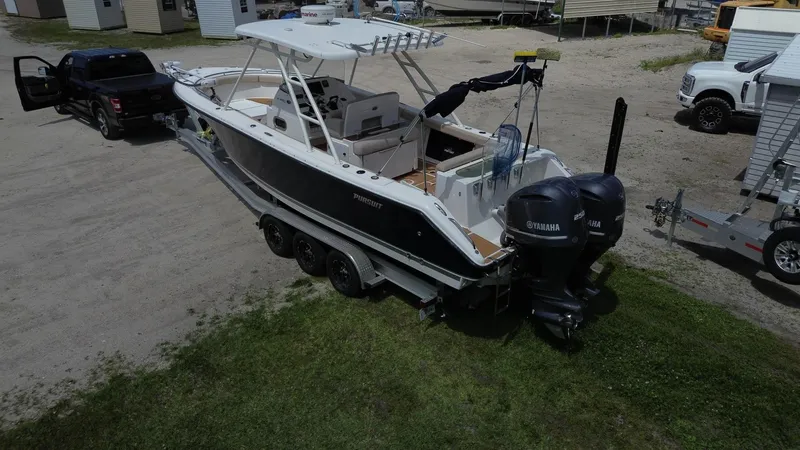 Slide: The Image of 2015 Pursuit S 280 Sport boat on trailer, parked near trucks. - 11
