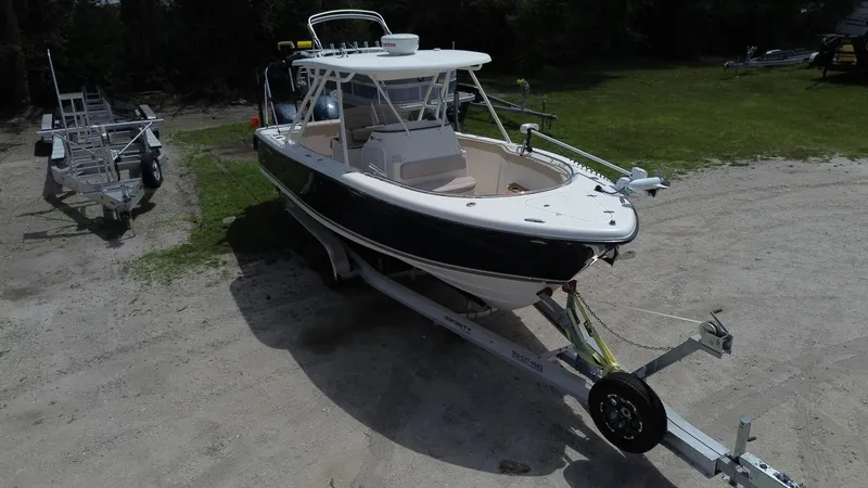 Slide: The Image of 2015 Pursuit S 280 Sport boat on trailer, parked on grassy area. - 14