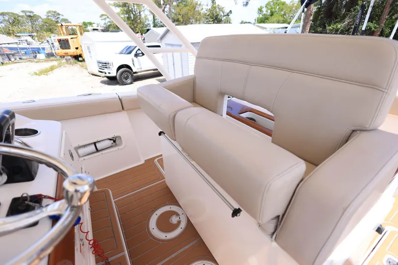 Slide: The Image of 2015 Pursuit S 280 Sport boat interior with beige seating and steering wheel. - 23
