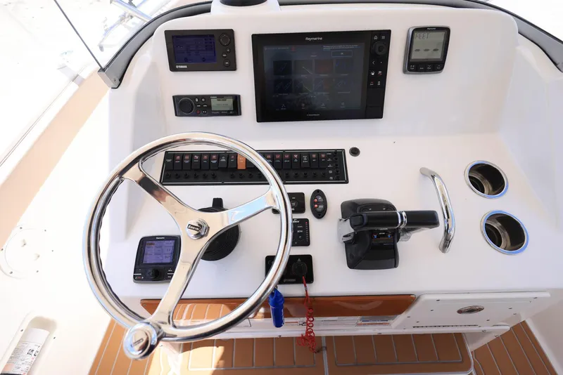 Slide: The Image of 2015 Pursuit S 280 Sport boat dashboard with steering wheel and navigation controls. - 24