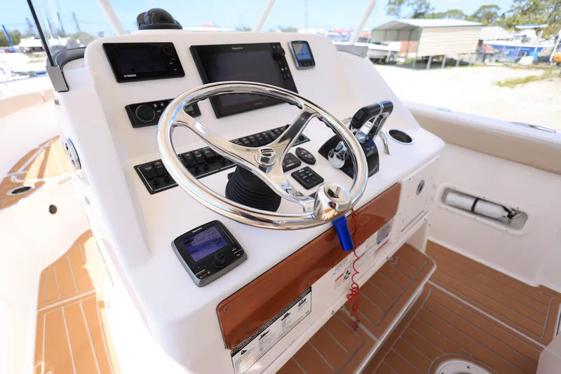 Slide: The Image of Control panel of a 2015 Pursuit S 280 Sport boat with steering wheel and navigation instruments. - 26