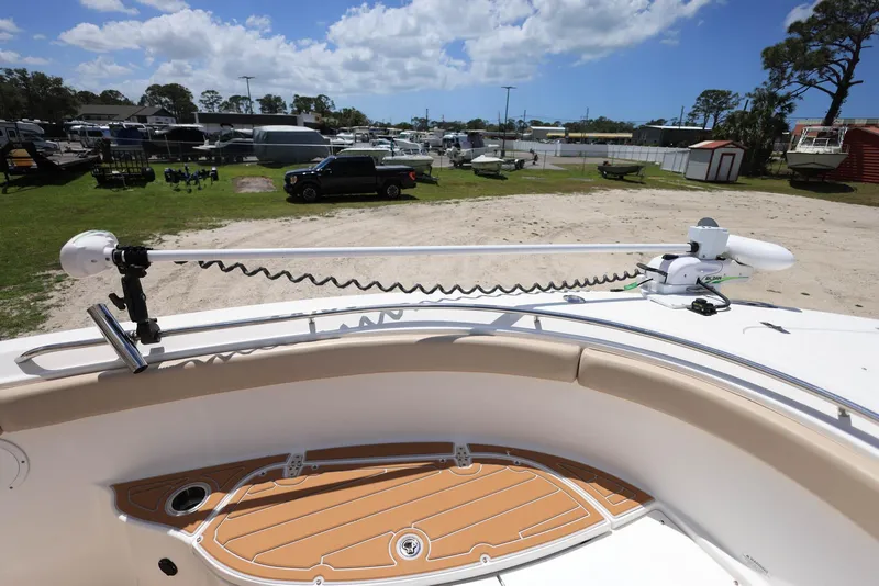 Slide: The Image of 2015 Pursuit S 280 Sport boat with trolling motor, parked outdoors under a blue sky. - 31