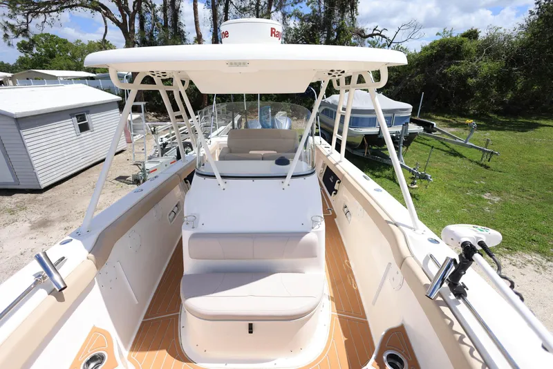 Slide: The Image of 2015 Pursuit S 280 Sport boat with spacious deck and seating, docked outdoors. - 32