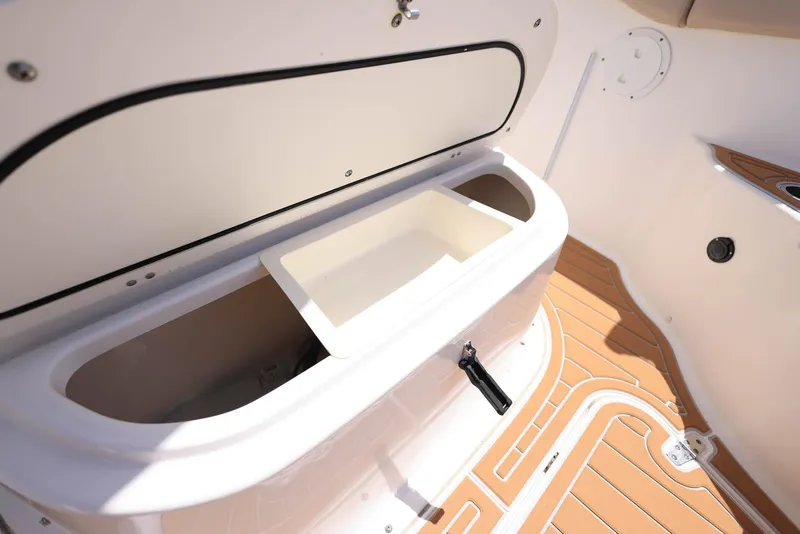 Slide: The Image of 2015 Pursuit S 280 Sport boat storage compartment with wooden deck flooring. - 34