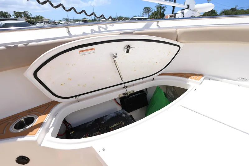 Slide: The Image of 2015 Pursuit S 280 Sport boat storage compartment open under sunny sky. - 35