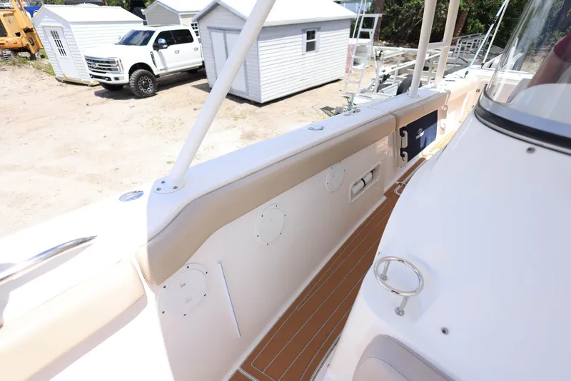 Slide: The Image of 2015 Pursuit S 280 Sport boat deck with white railing and wood flooring. - 37
