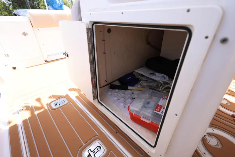 Slide: The Image of Storage compartment on 2015 Pursuit S 280 Sport boat, containing various items. - 41