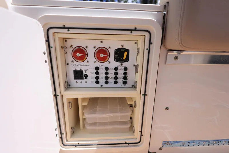 Slide: The Image of Control panel on a 2015 Pursuit S 280 Sport boat, featuring switches and storage compartment. - 42