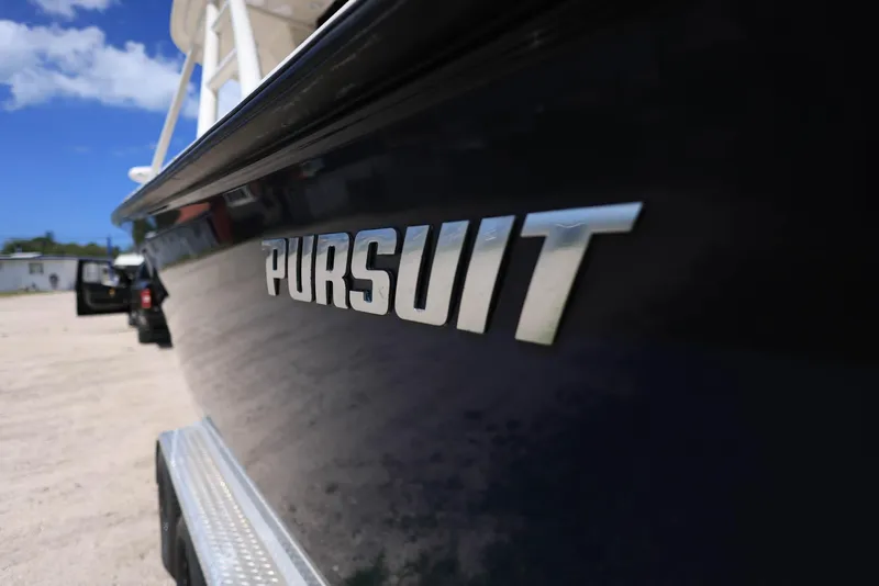 Slide: The Image of 2015 Pursuit S 280 Sport boat with logo, parked on sandy beach. - 7