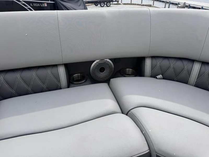 Slide: The Image of 2022 Bennington LX24FB boat interior with gray cushioned seating and speaker. - 12