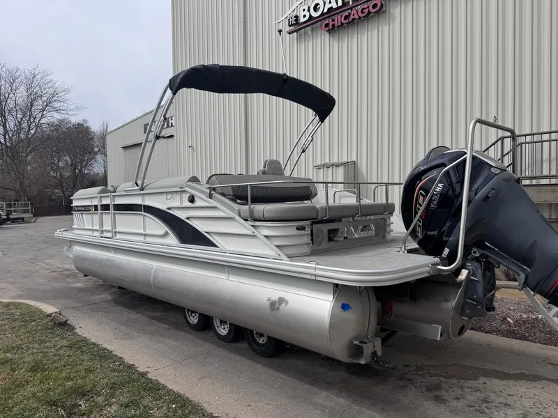 Slide: The Image of 2022 Bennington LX24FB pontoon boat with outboard motor, docked near a building. - 3