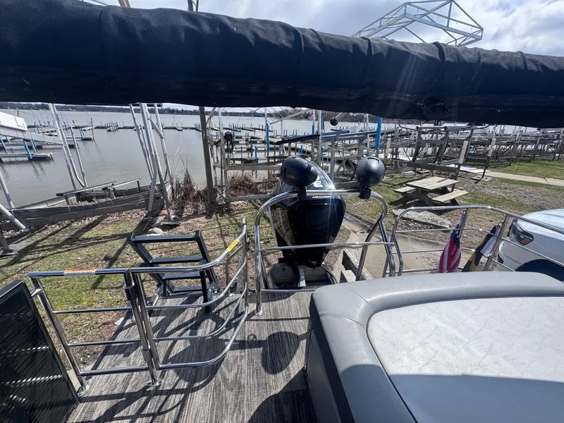 Slide: The Image of 2021 Sweetwater 2486SFL pontoon boat docked at a marina with outboard motor. - 12