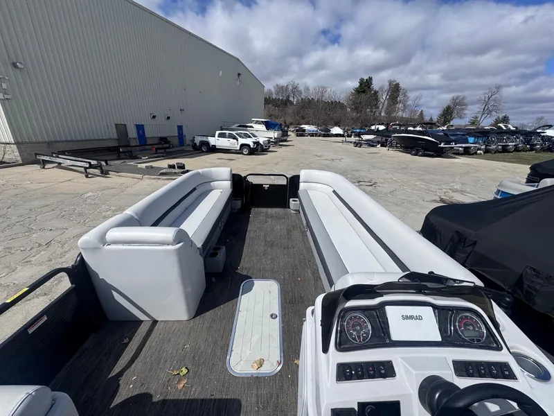 Slide: The Image of 2021 Sweetwater 2486SFL pontoon boat with spacious seating, parked outdoors under cloudy sky. - 14