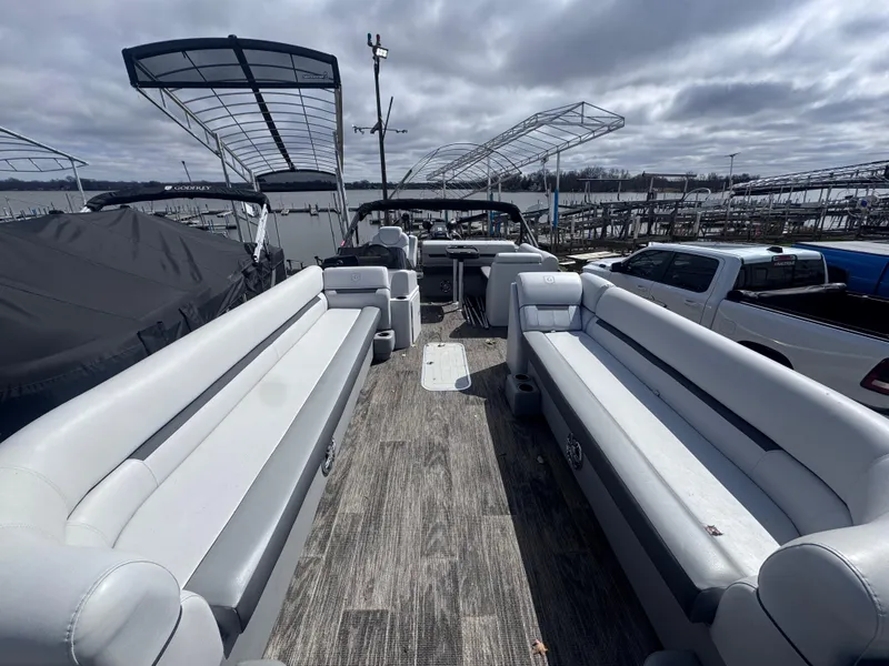 Slide: The Image of 2021 Sweetwater 2486SFL pontoon boat with spacious seating, docked under cloudy skies. - 3
