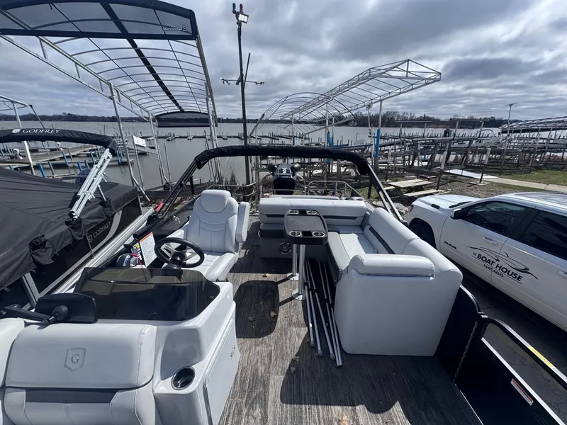 Slide: The Image of 2021 Sweetwater 2486SFL pontoon boat interior with seating, docked near a lake. - 6