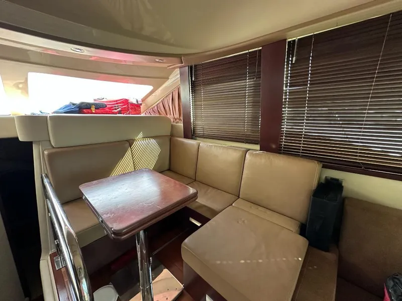 Slide: The Image of Interior of 2007 Sea Ray 360 Sedan Bridge with beige seating and wooden table. - 14