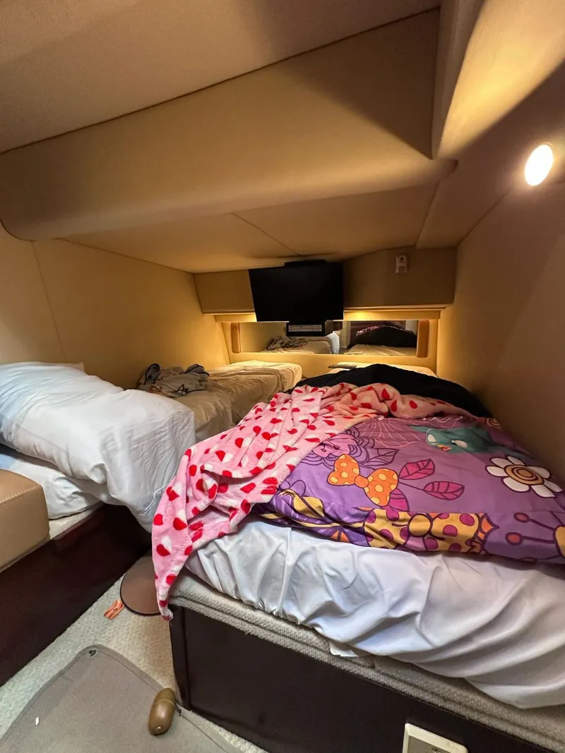 Slide: The Image of Cozy cabin interior of 2007 Sea Ray 360 Sedan Bridge with colorful bedding and soft lighting. - 17