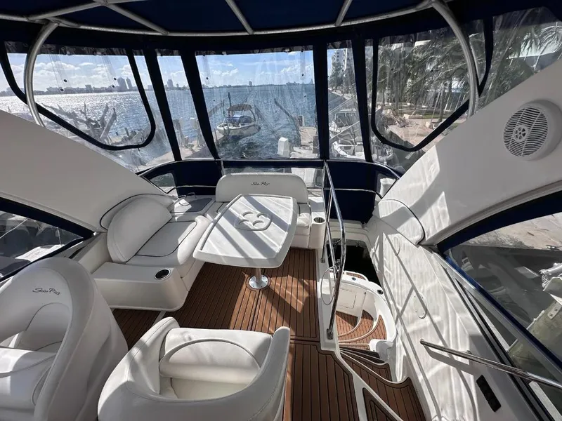 Slide: The Image of 2007 Sea Ray 360 Sedan Bridge interior with white seating and waterfront view. - 9
