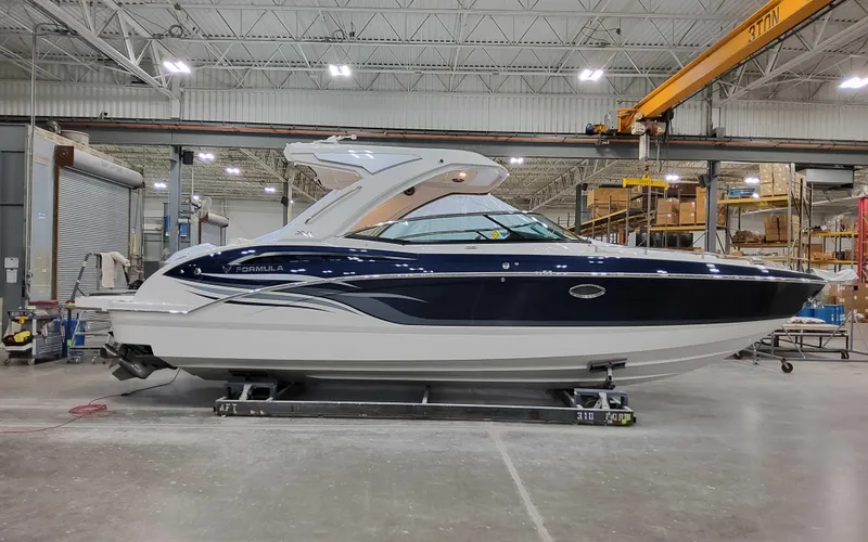 Slide: The Image of 2025 Formula 310 Bowrider boat in a warehouse, side view. - 1