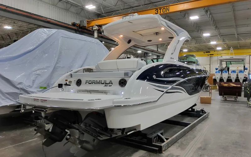 Slide: The Image of 2025 Formula 310 Bowrider in a warehouse, showcasing sleek design and modern features. - 2