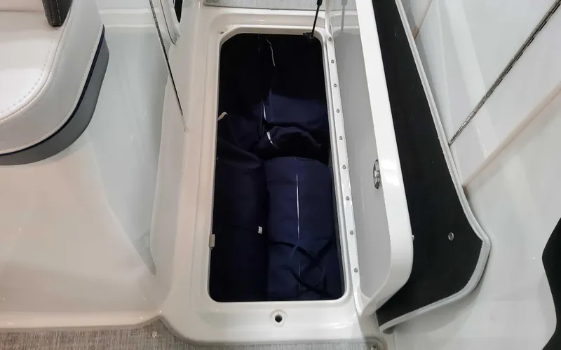 Slide: The Image of Storage compartment in 2025 Formula 310 Bowrider boat, featuring neatly packed items. - 21