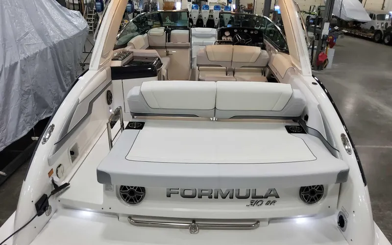 Slide: The Image of 2025 Formula 310 Bowrider boat interior with seating and branded details in a showroom. - 5