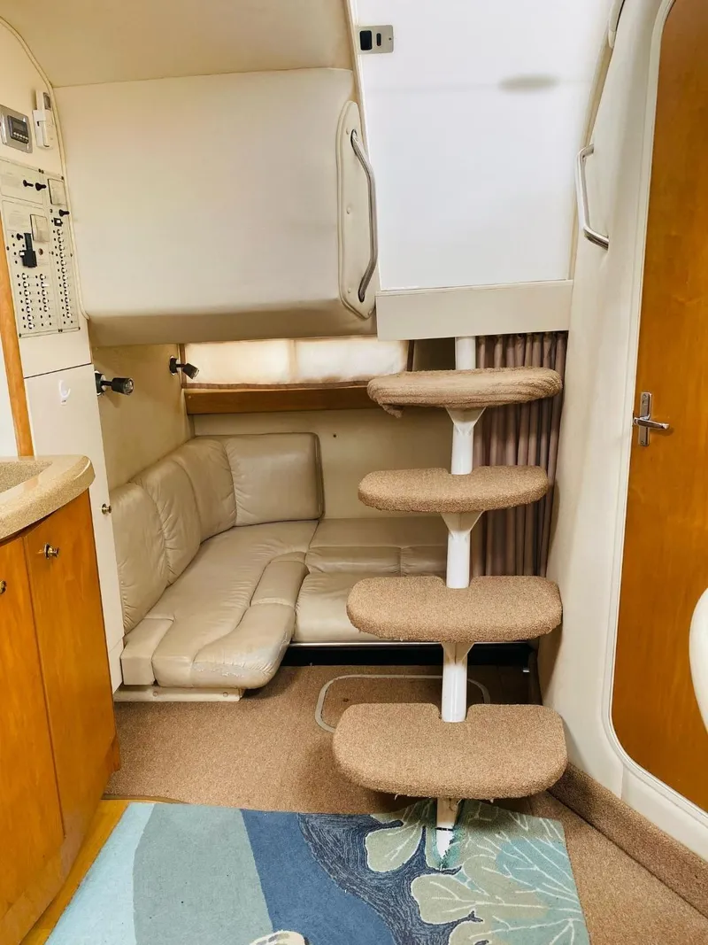 Slide: The Image of Interior of a 2003 Larson 310 boat with cozy seating and carpeted stairs. - 11