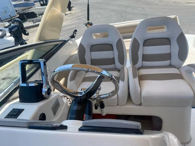Slide: The Image of Interior of a 2003 Larson 310 boat with dual seats and steering wheel. - 12